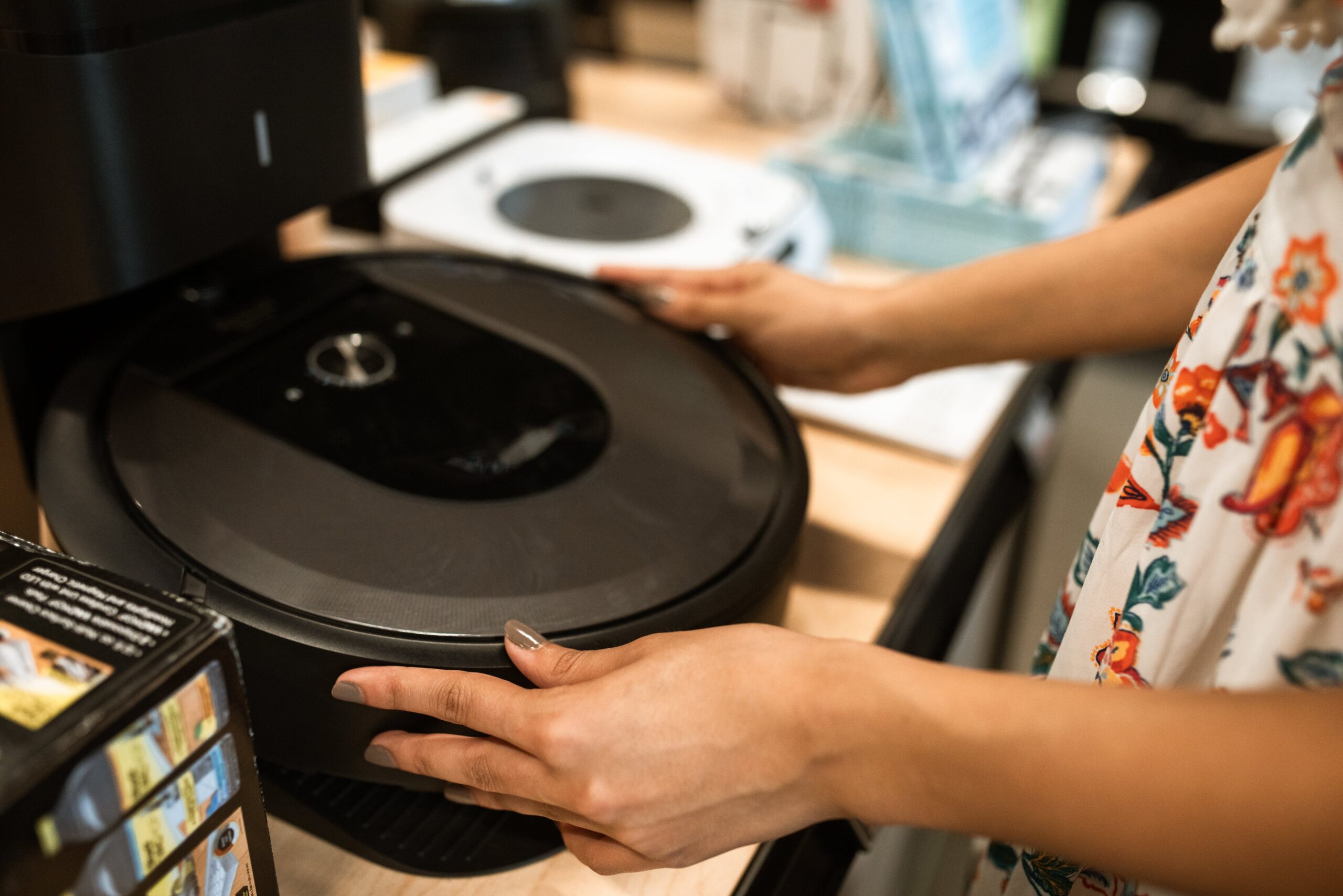 the person holding a robotic vacuum cleaner