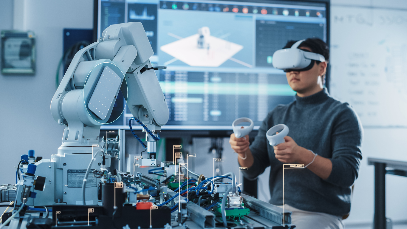 Computer science engineer in virtual reality headset using controllers and operating robot arm under his control