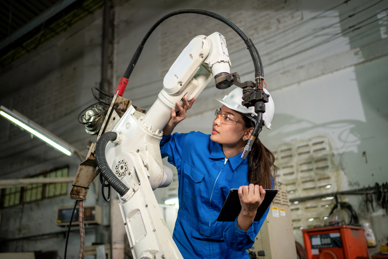 Technician woman check the robotic arm machine in the factory