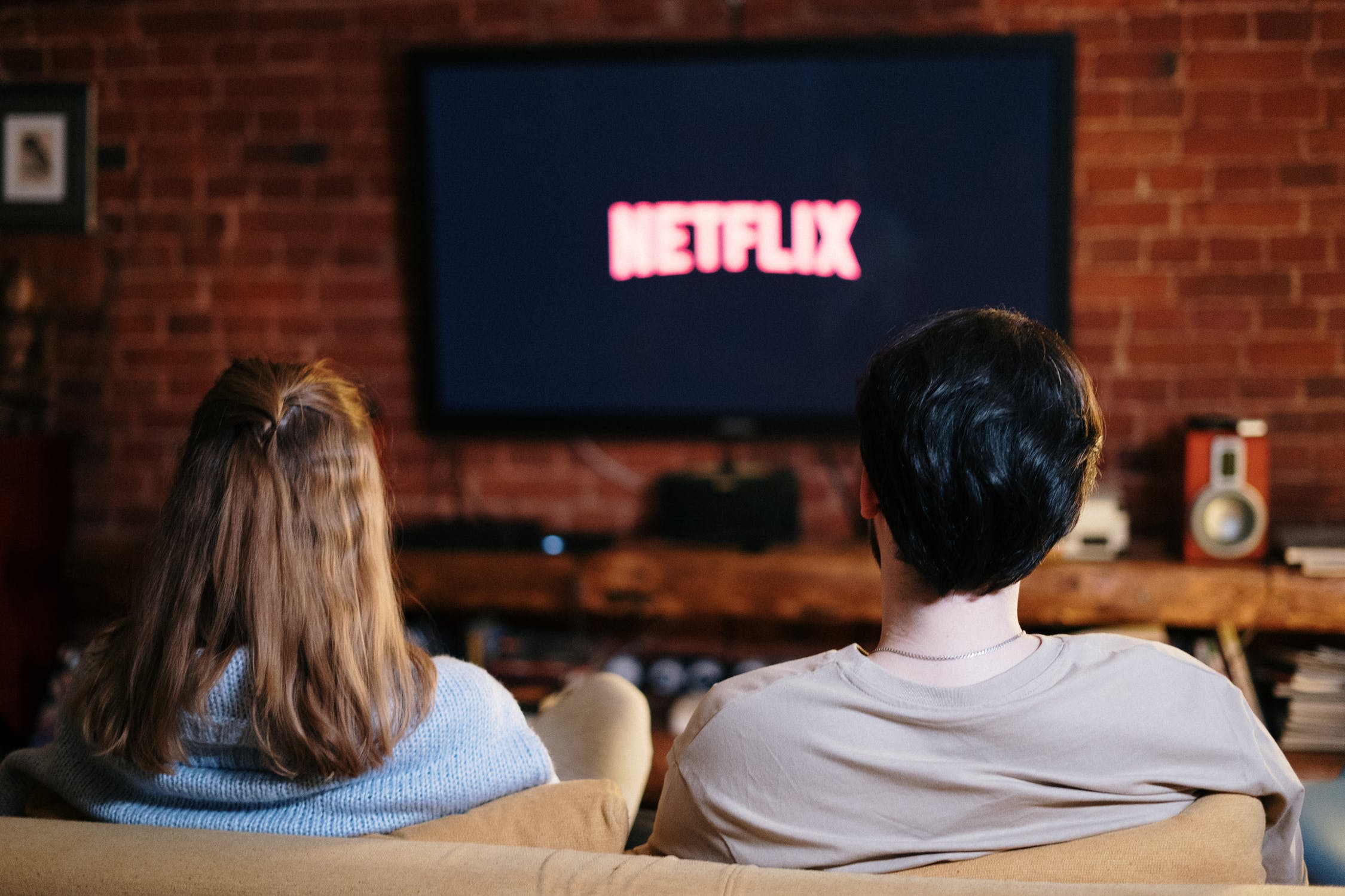 man and woman watching Netflix on TV