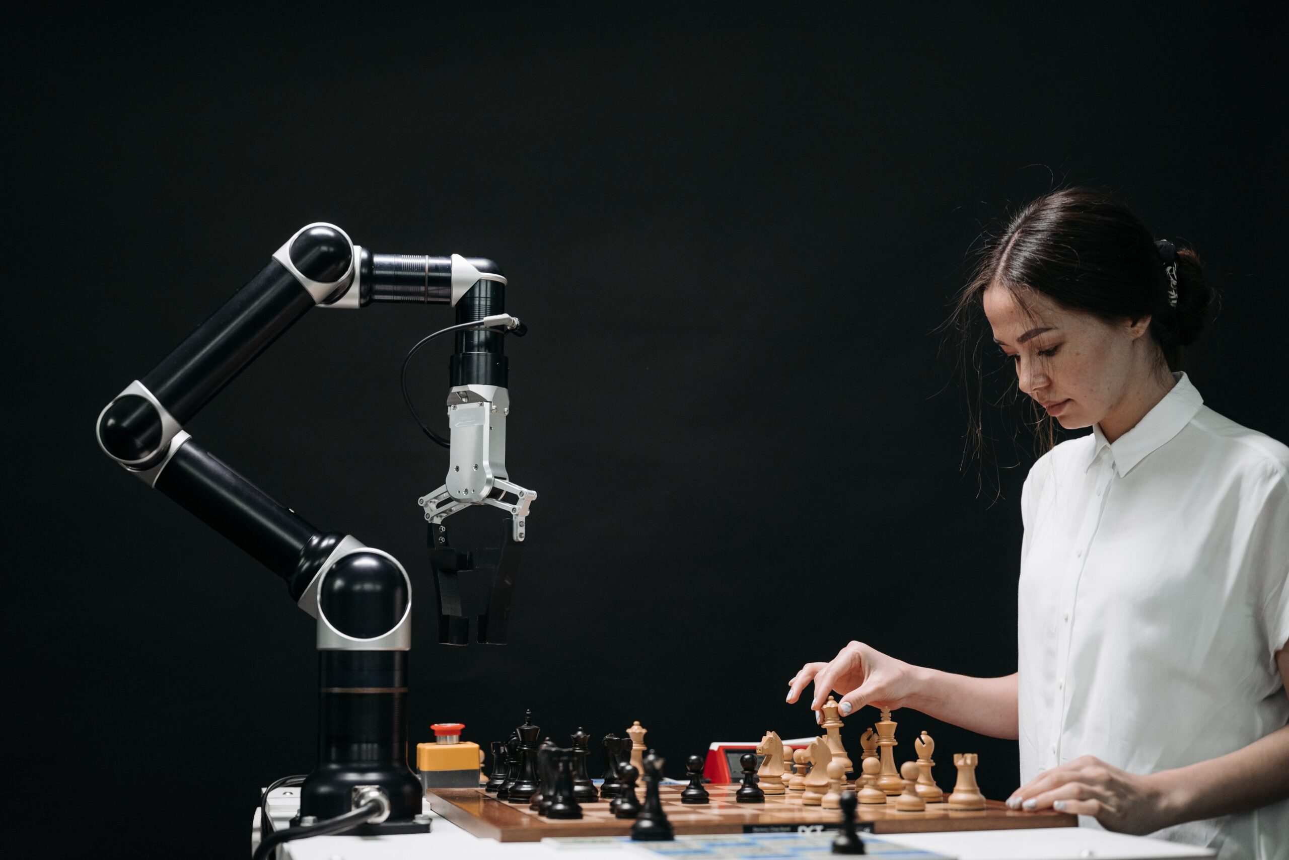 woman in a white shirt playing chess against a robot